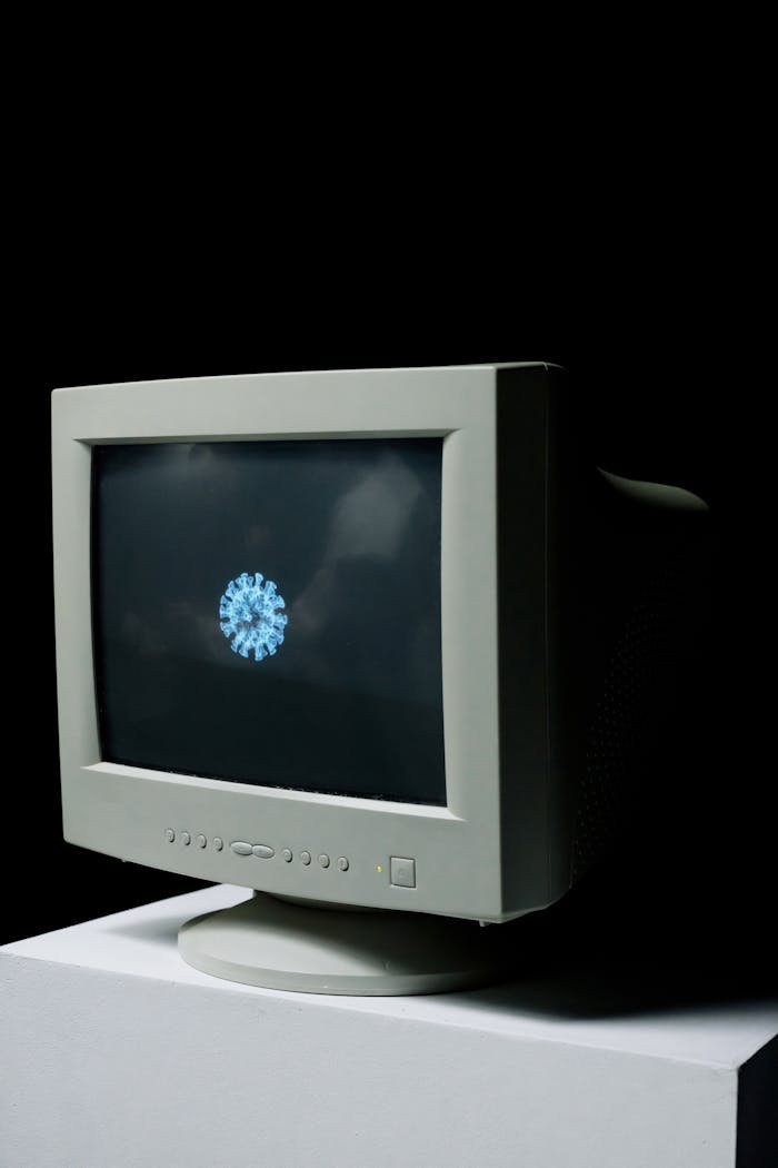 An old CRT monitor displaying a digital representation of a virus on a black background.